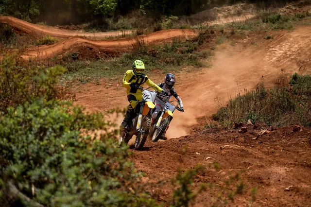 Two riders run a rutted laterite trail side by side.
